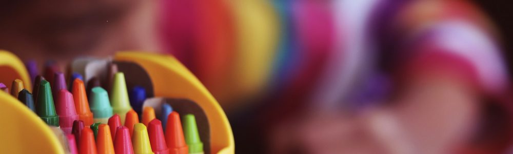 selective focal photo of crayons in yellow box